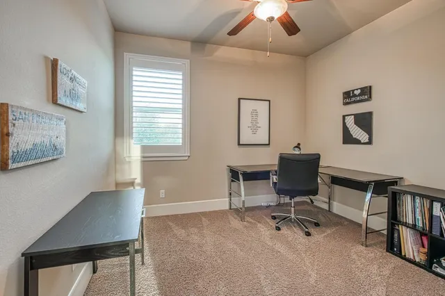 a view of a workspace with furniture and a window