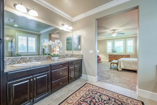a spacious bathroom with a granite countertop sink and a mirror