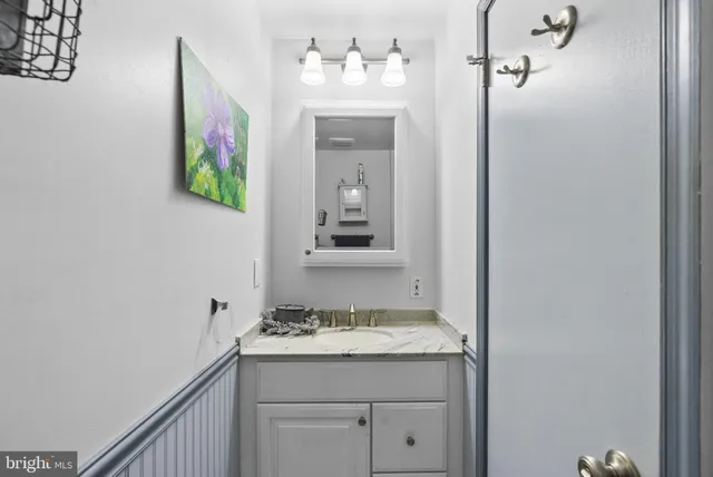 a bathroom with a granite countertop sink and a mirror