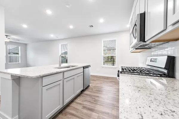 a bathroom with a granite countertop sink a mirror and a shower