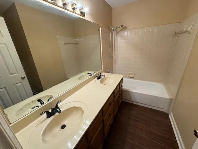 a bathroom with a tub sink and mirror