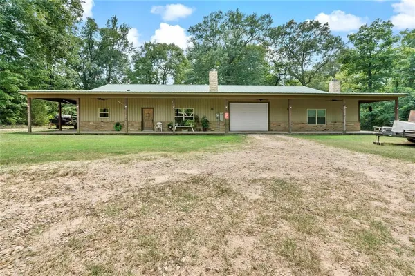 a view of a big house in a big yard with large trees