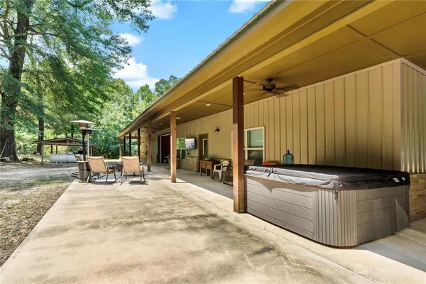 a view of a patio with table and chairs under an umbrella with wooden fence