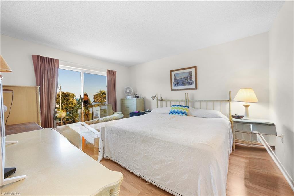 5 High Point Circle West, Unit 313 Naples, FL 34103 - Photo 3 of 24 a spacious bedroom with a bed and a couch