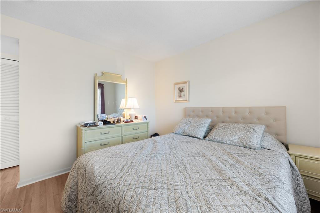 5 High Point Circle West, Unit 313 Naples, FL 34103 - Photo 6 of 24 a bedroom with a bed and a dresser in it