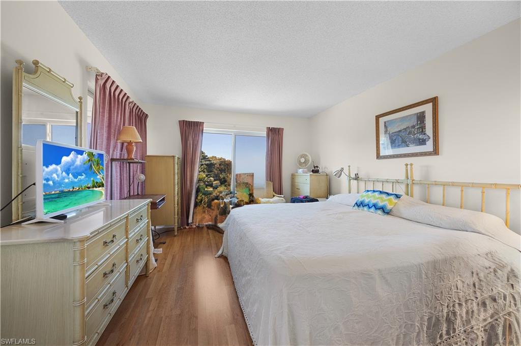 5 High Point Circle West, Unit 313 Naples, FL 34103 - Photo 7 of 24 a bedroom with furniture and a flat screen tv