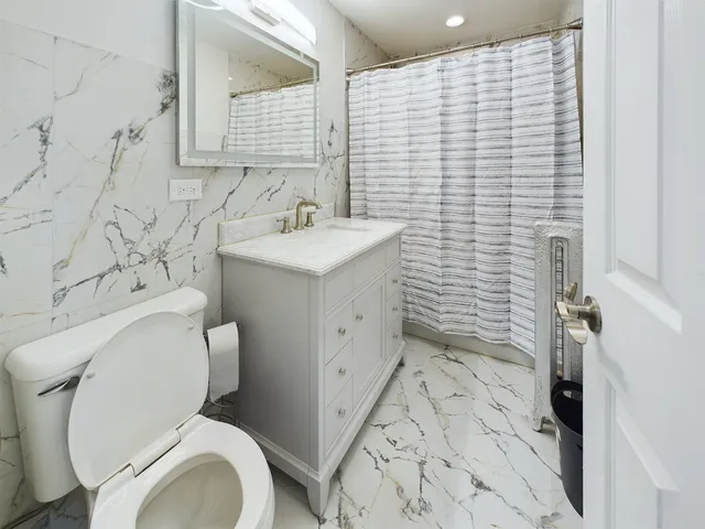 a bathroom with a sink a toilet and shower