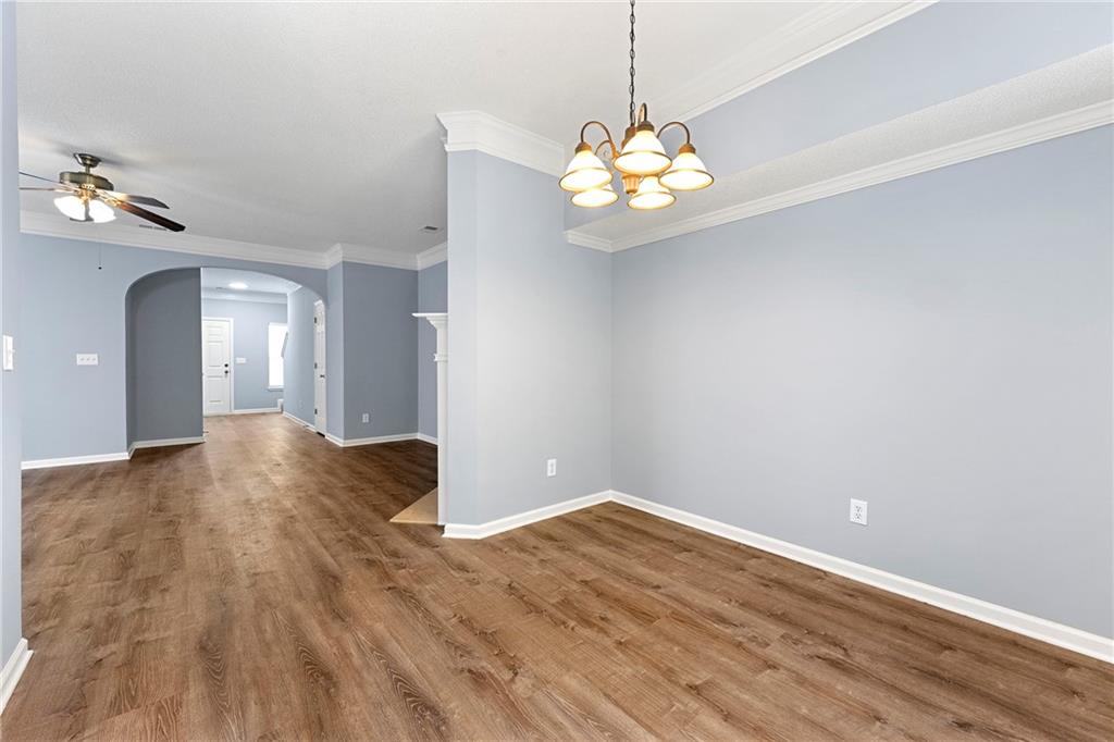 5654 Lawley Road Alpharetta, GA 30022 - Photo 14 of 29 a view of an empty room with chandelier fan and wooden floor
