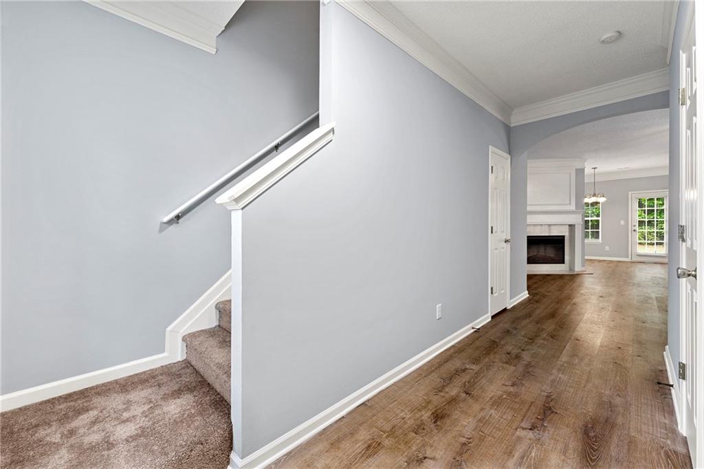 5654 Lawley Road Alpharetta, GA 30022 - Photo 5 of 29 a view of a hallway with wooden floor and staircase