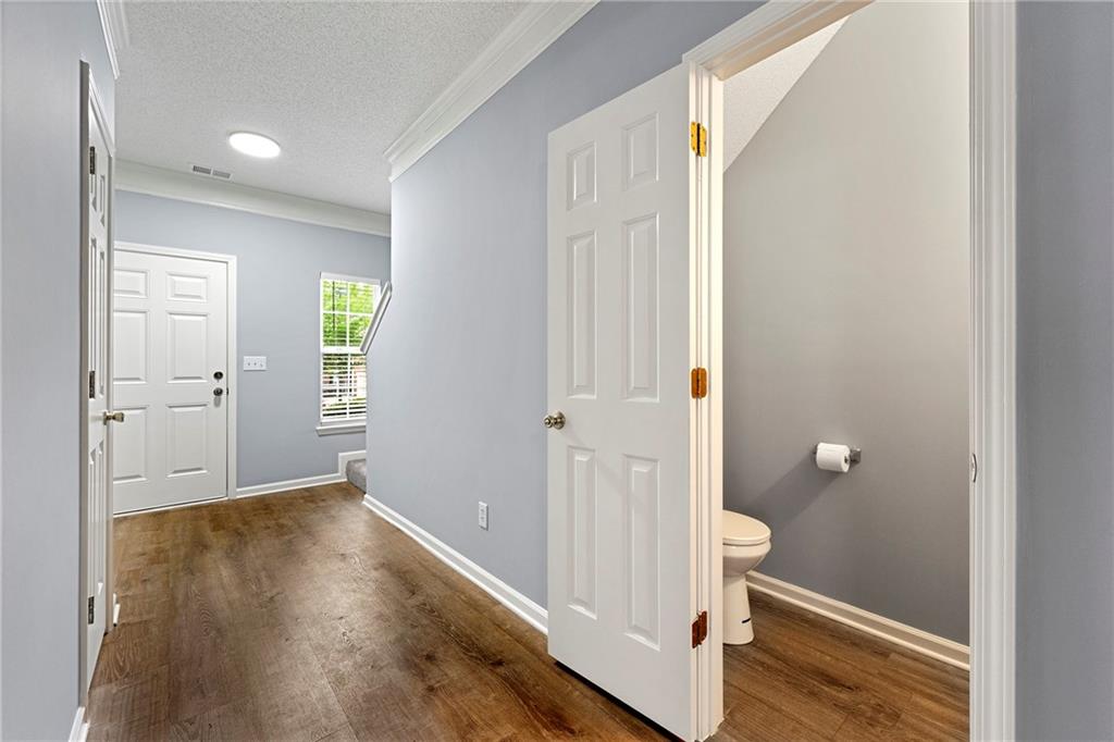 5654 Lawley Road Alpharetta, GA 30022 - Photo 6 of 29 a view of a hallway with wooden floor and closet area