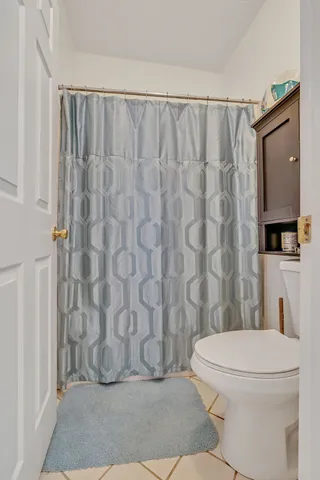 a bathroom with a toilet and a shower curtain