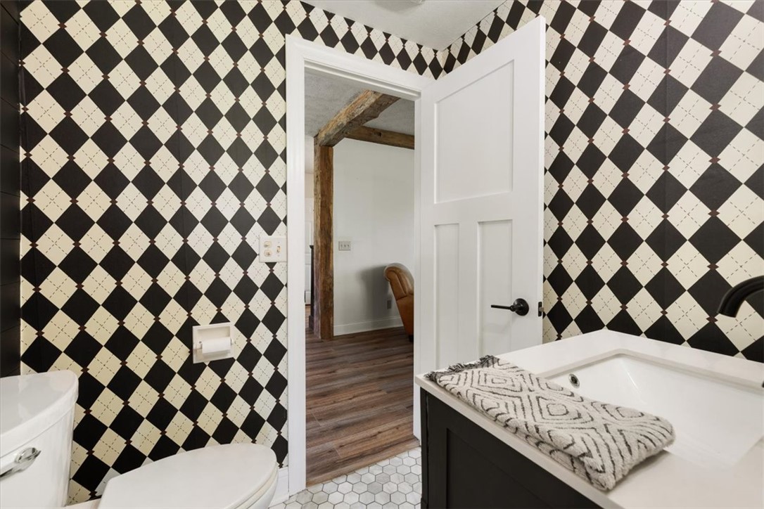 5120 Wheelock Road Troy, OH 45373 - Photo 23 of 67 This bathroom features stylish patterned wallpaper, a modern vanity, and hexagonal tile flooring.