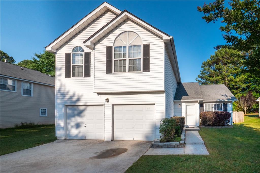 2719 Rambling Way Lithonia, GA 30058 - Photo 1 of 1 a front view of a house with a yard and garage
