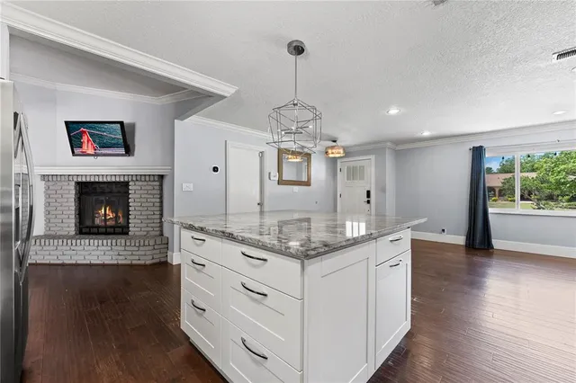 a open kitchen with a fireplace and wooden floor