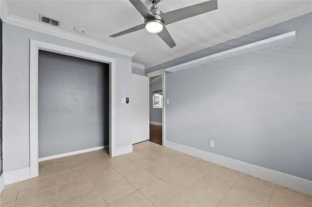 an empty room with ceiling fan and fan