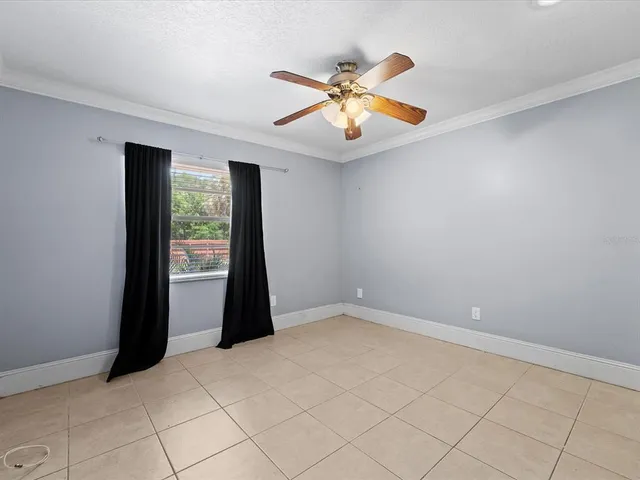 an empty room with windows and fan