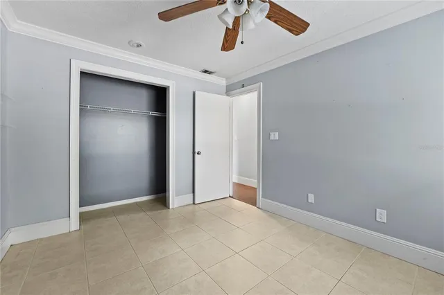 an empty room with windows and fan