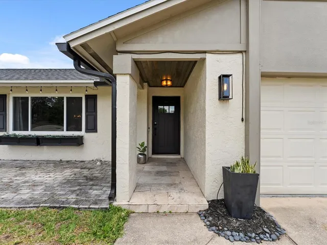 a front view of a house with potted plants