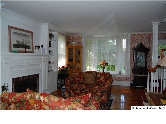 90 Aberdeen Road Matawan, NJ 07747 - Photo 1 of 3 a living room with furniture a fireplace and a large mirror