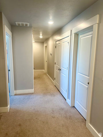 1148 290 South Logan, UT 84321 - Photo 14 of 34 Recessed lighting illuminates the hallway, featuring light-colored carpeting, white trim, and white paneled doors