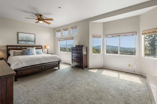 a bedroom with a bed and a large window