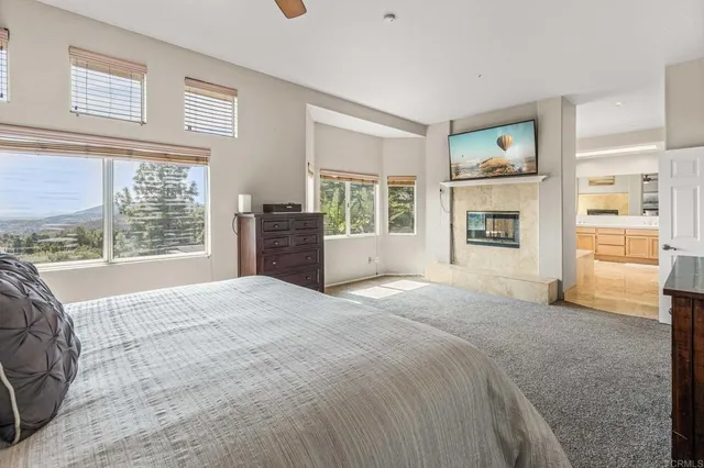 a large bedroom with a large bed a flat tv screen and balcony