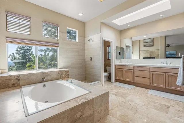 a spacious bathroom with a tub sink and mirror