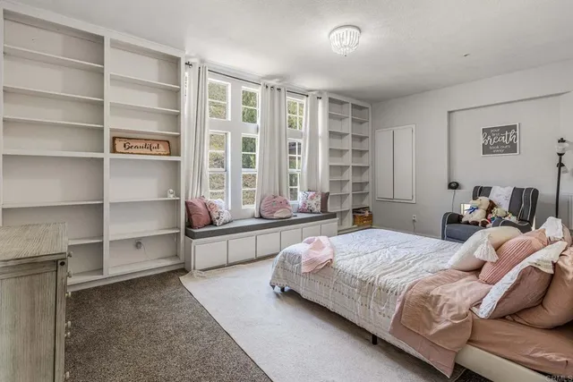 a bedroom with bed and a large window