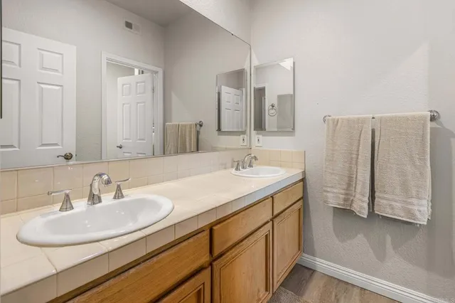 a bathroom with a double vanity sink and a mirror