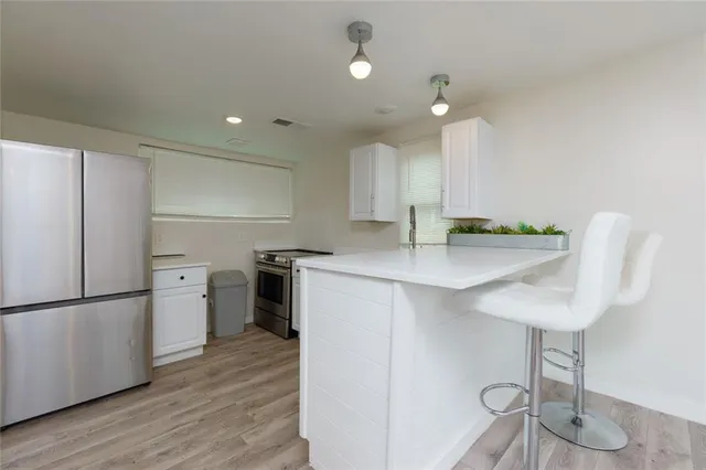 a kitchen with white cabinets and appliances