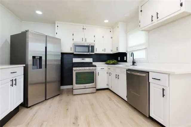 a kitchen with stainless steel appliances a refrigerator sink and cabinets