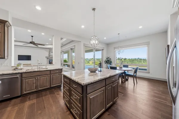 a kitchen with counter top space a sink appliances and wooden floor
