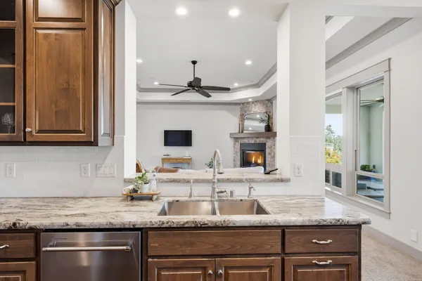 a kitchen with granite countertop a sink and a refrigerator