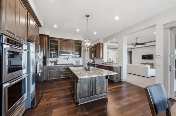 a kitchen with stainless steel appliances granite countertop a sink refrigerator and cabinets
