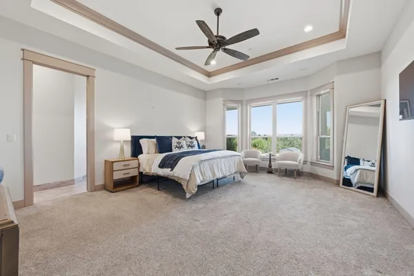 a spacious bedroom with a bed and a ceiling fan