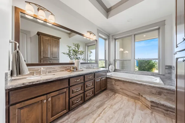 a bathroom with a granite countertop sink and a large mirror