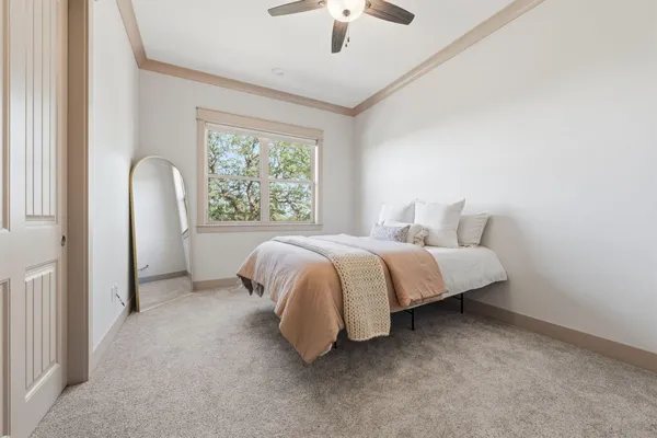 a spacious bedroom with a bed and a chandelier