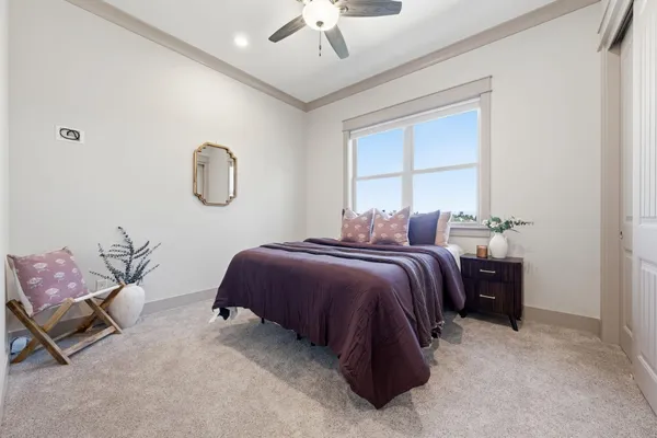 a bedroom with a bed a chandelier and a window