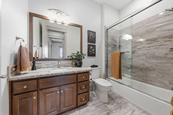 a bathroom with a double vanity sink toilet and shower