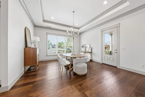 a dining room with furniture a chandelier and wooden floor