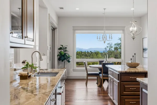 a dining room with furniture a large window and kitchen view