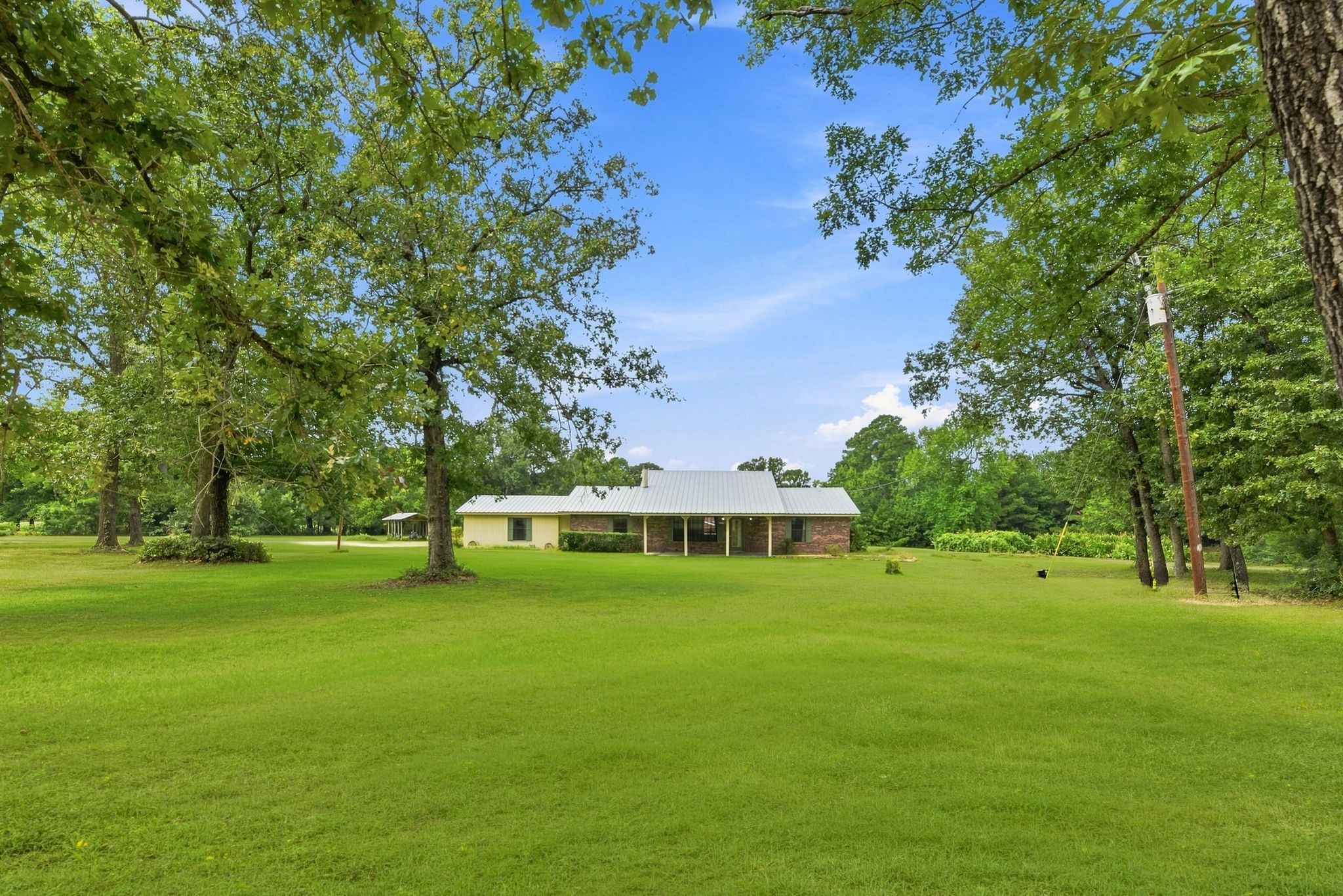 151 Parker Road New Waverly, TX 77358 - Photo 3 of 36 Charming home set on expansive, lush green grounds, surrounded by mature trees, offering serene privacy and natural beauty.