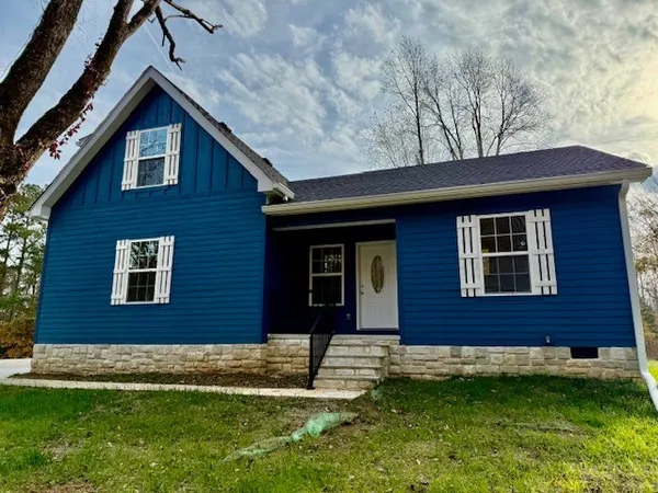 a brick house that has a small yard in front of it