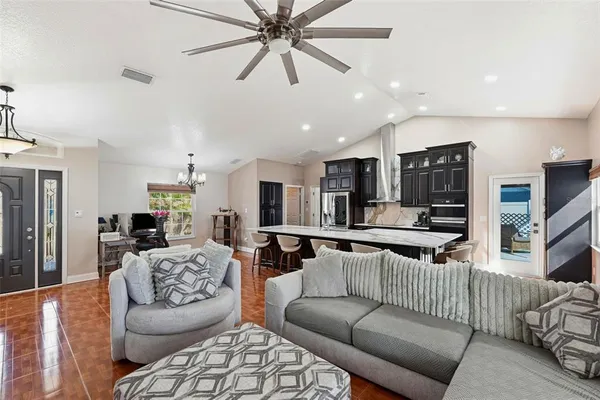 a living room with furniture kitchen view and a flat screen tv