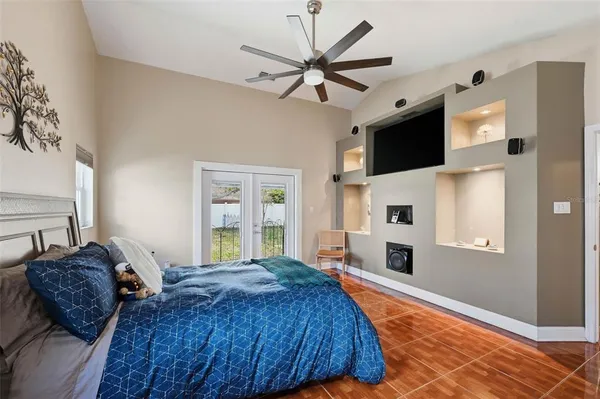 a spacious bedroom with a bed and a flat screen tv