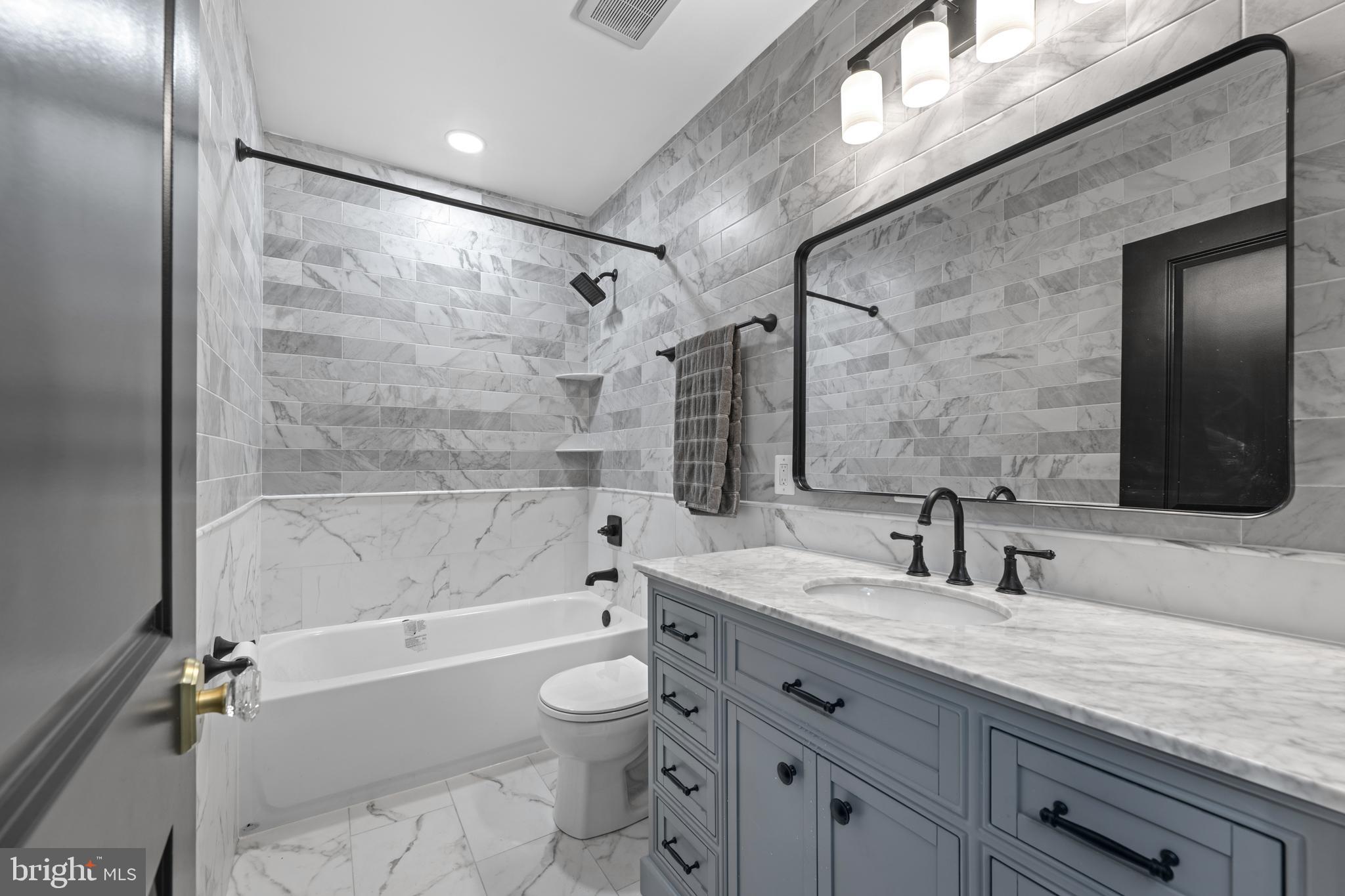 422 11th Street Southeast Washington, DC 20003 - Photo 27 of 51 a bathroom with a granite countertop sink a toilet and shower