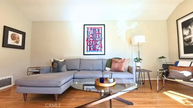 a living room with furniture and a wooden floor