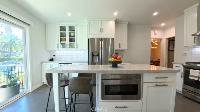 a kitchen with a table chairs refrigerator and microwave