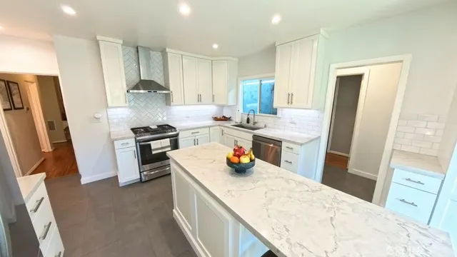 a kitchen with stainless steel appliances a sink a refrigerator a stove a microwave and cabinets