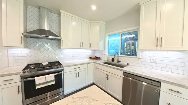 a kitchen with granite countertop a sink stove and cabinets